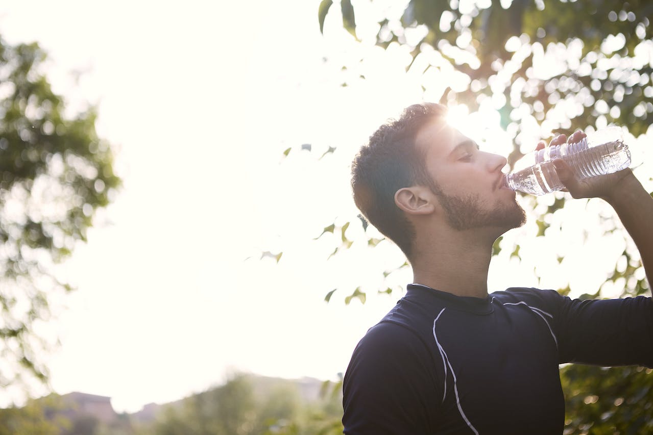 Male runner drink water  while running