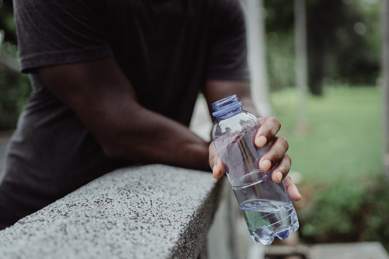 Runner staying hydrated to prevent cramps while running
