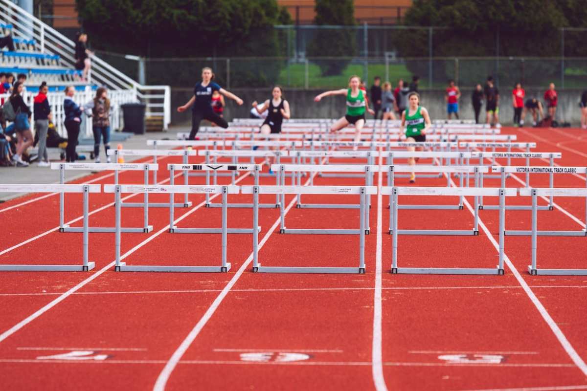 Athletes leaping over hurdles in a track and field hurdling event