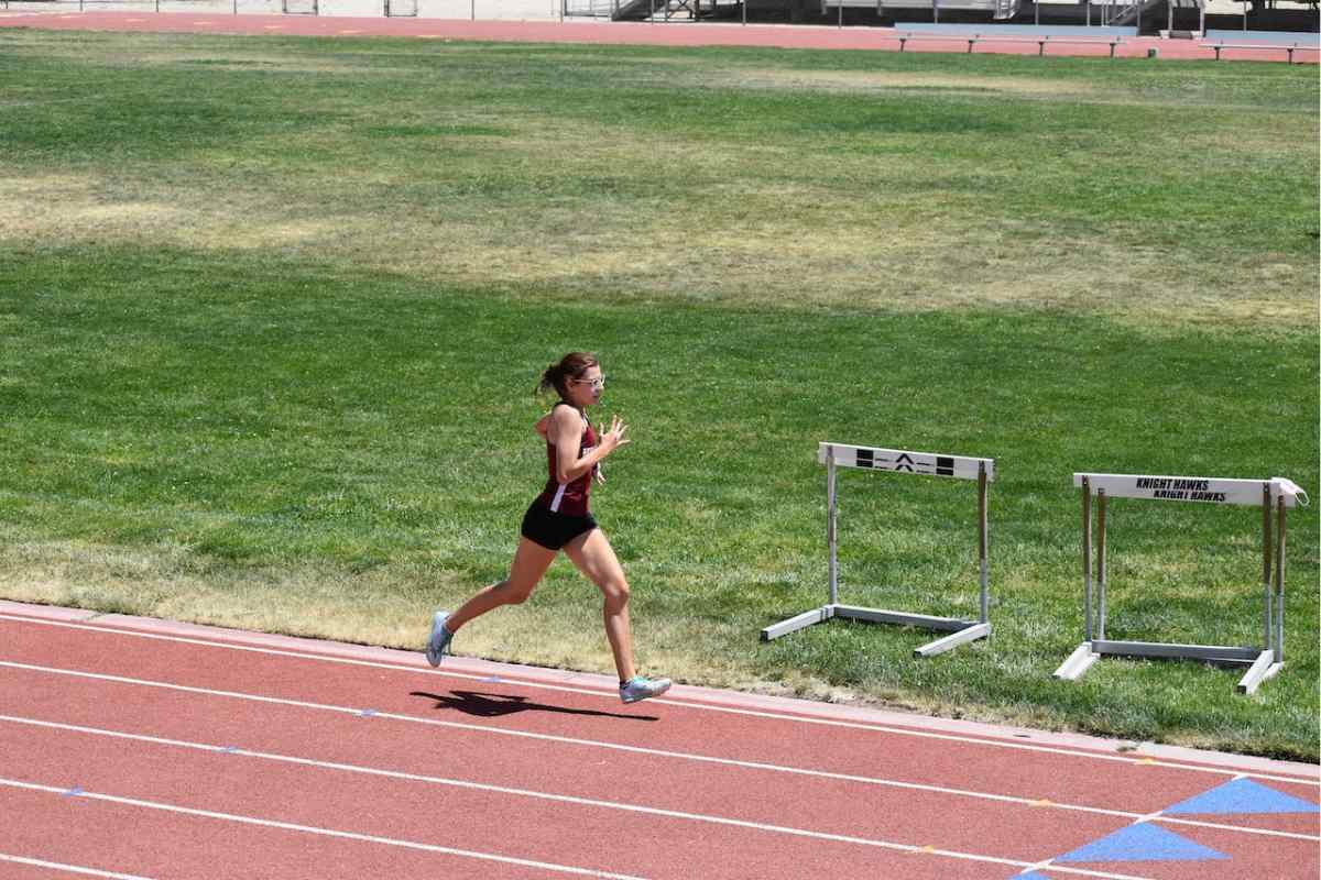 female athlete running on a track at a slower pace