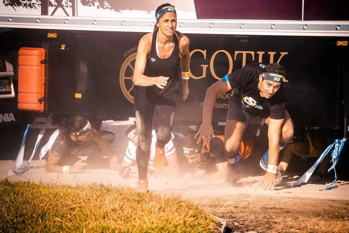 Athletes engaging in a competitive obstacles course race, such as Spartan Race or Tough Mudder