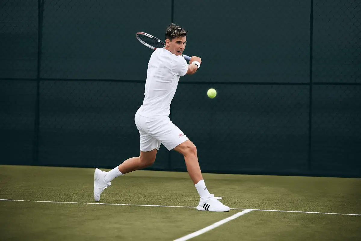 Man playing in tennis with Adidas's specialized footwear
